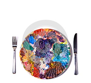 Colorful paint palette with fork and knife.