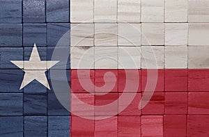 colorful painted big national flag of texas state on a wooden cubes texture