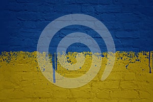 colorful painted big national flag of ukraine on a massive brick wall