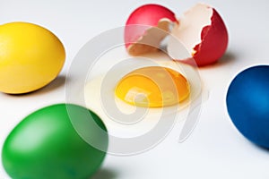 Colorful painted eggs with spilled yolk of cracked one