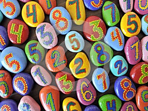 Colorful painted numbers on natural stones