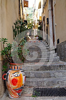 colorful painted vases and flower pots on narrow stairs in the old town of Taormina, Sicily