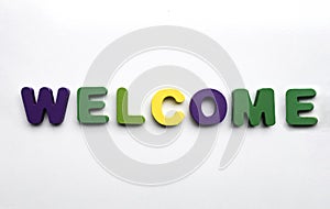 colorful painted wood word WELCOME made from many wooden letters  on white background