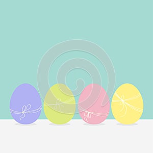 Colorful painting Easter egg set. Row of painted eggs shell with thread and bow. Light color. Blue background. Isolated. Greeting