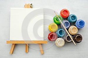 Colorful paints with paint brush and canvas on the easels.