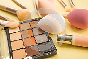 Colorful palette of eyeshadows and blushers. Professional makeup brushes and tools on white background