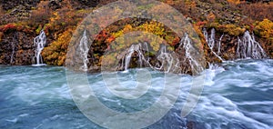 A colorful panorama view of Hraunfossar waterfalls in autumn