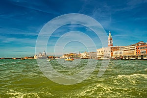 Colorful panoramic view of Doge Palace, Campanile and San Marco square from busy Grand Canal water during sunset, Venice, Italy,