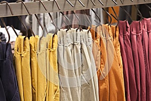 Colorful pants hanging displaying on a rack in store