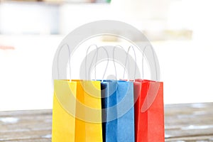 Colorful paper bags on the table on a light blurred background