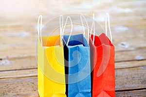 Colorful paper bags on the table on a wooden background