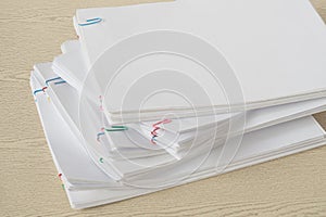 Colorful paper clip with pile of overload document and reports