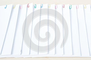 Colorful paper clip with pile overload paperwork on wood table