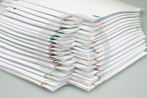 Colorful paper clip with pile of paper reports arranged on table