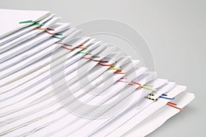 Colorful paper clip with pile of reports arranged on table