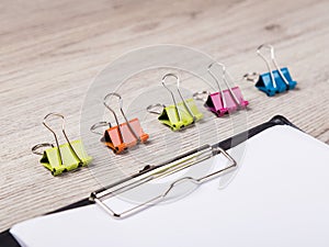 Colorful paper clip on wood background