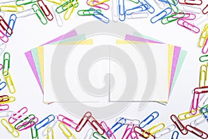 Colorful paper clips and note papers in the centre of composition isolated on white