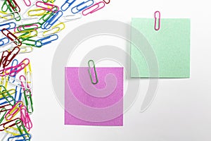 Colorful paper clips and note papers isolated on white