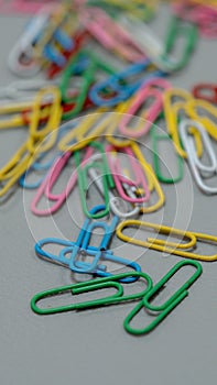 colorful paper clips rests on a sleek gray surface