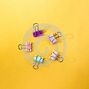 Colorful paper clips on a yellow backdrop