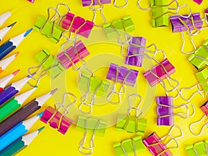 colorful paper clips on yellow background. School and office concept. Back to school background