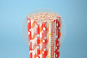 Colorful paper drinking straws on light blue background, closeup