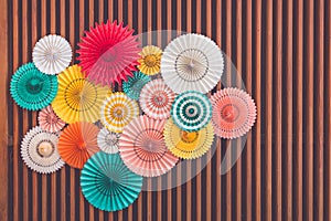 colorful paper fans on wood beams wall
