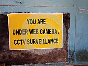 A colorful paper notice mentioning that we are under Web or cctv camera.