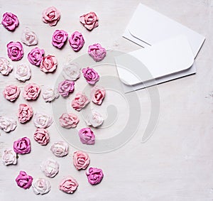 Colorful paper roses with envelopes, Valentine's Day border ,with text area white wooden rustic background top view close up