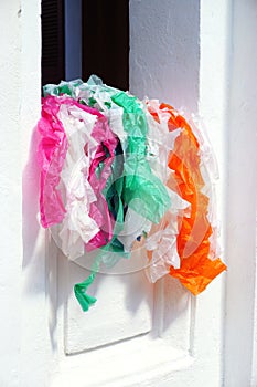 Colorful paper streamers spill out of a window in Luang Prabang, Laos
