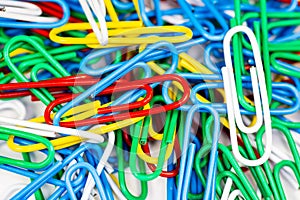 Colorful paperclips bunched up on a white surface