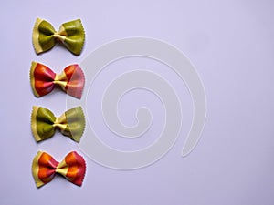 Colorful Pasta, Loop Noodles, Italian Pasta, four Farfalle.  Closeup, in a row,  one below the othe,  in front of white background