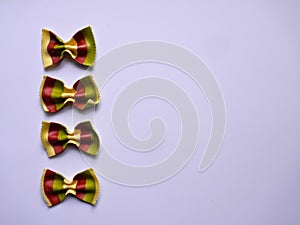 Colorful Pasta, Loop Noodles, Italian Pasta, four Farfalle.  Closeup, in a row, one below the other, in front of white background