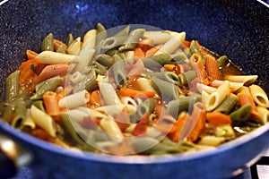 Colorful pasta pieces in pan