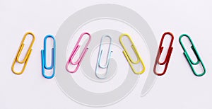 Colorful pastel paper clips isolated over white background. Red, pink, yellow, blue and green plastic paperclips