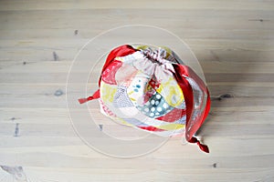 Colorful patchwork draw string bag on table