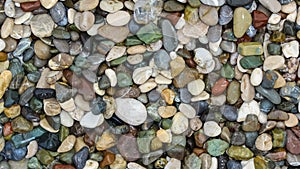 Colorful pebbles on beach top view, rotating