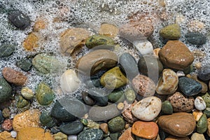 Colorful pebbles in sea at Mediterranean beach. Texture, background concept