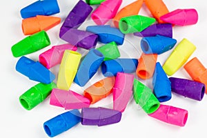 Colorful pencil erasers cluttered on a white surface