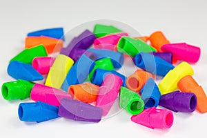 Colorful pencil erasers cluttered on a white surface