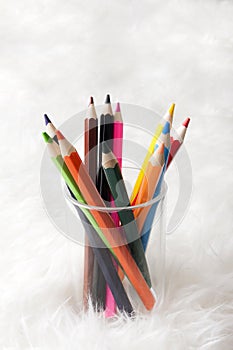 Colorful pencil in a glass on background