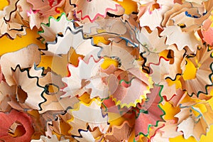 Colorful pencil shavings on yellow background. Back to school concept