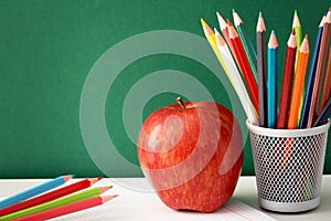 Colorful pencils and apple