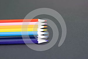 Colorful pencils arranged in a wave isolated over black background