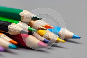 Colorful pencils arrangement on grey background close up