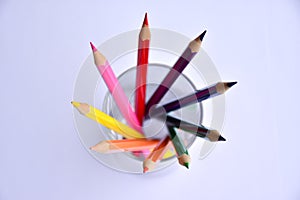 Colorful pencils in glass on white background