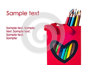 Colorful pencils in a red bag with heart shape