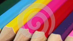 Colorful pencils rotate as a background. Rainbow pencils for drawing. Assortment of colored pencils. Back to school