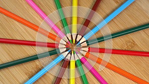 Colorful pencils rotate as sun rays background. Rainbow pencils for drawing. Assortment of colored pencils. Back to