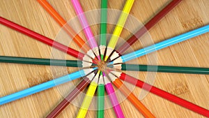 Colorful pencils rotate as sun rays background. Rainbow pencils for drawing. Assortment of colored pencils. Back to